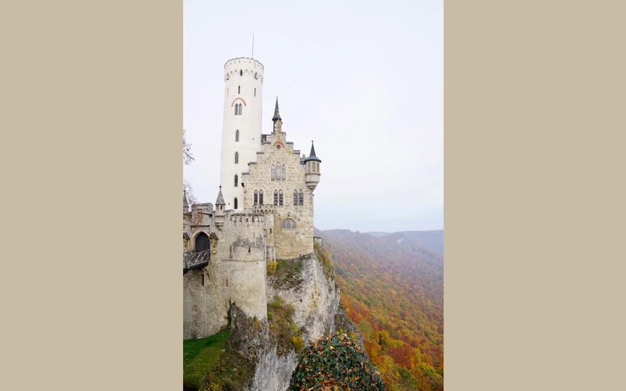 A fairytale-esque castle on a clifftop overlooks the changing fall leaves 